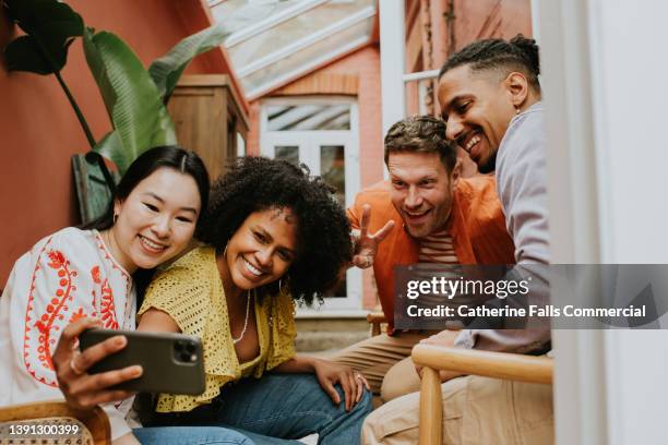 a group of 4 young people take a selfie on a mobile smart phone - generation y 個照片及圖片檔