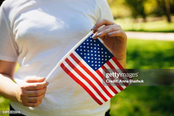 faceless woman holding usa national flag in hands in sunny summer day - american flag small stock pictures, royalty-free photos & images