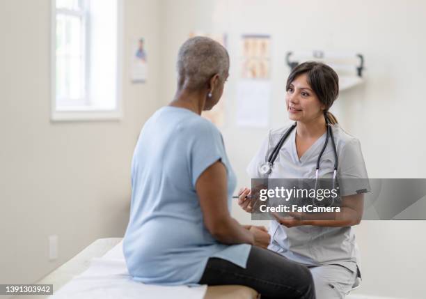 cancer patient having a check-up - doctor talking imagens e fotografias de stock