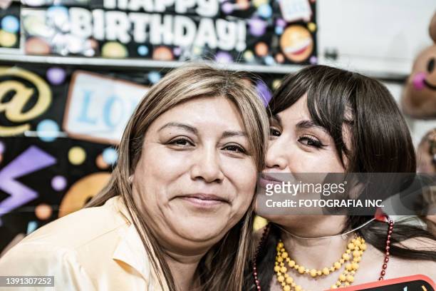 lateinamerikanische freundinnen lustiges porträt auf der fiesta-geburtstagsfeier - wange an wange stock-fotos und bilder