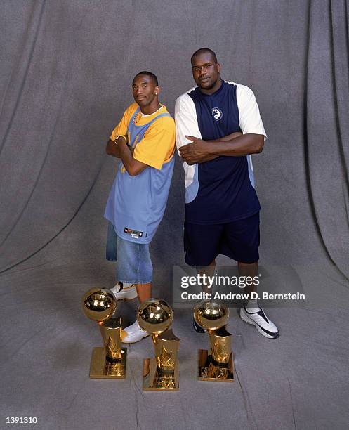 Guard Kobe Bryant and center Shaquille O'Neal of the Los Angeles Lakers pose for a studio portrait with their three championship trophies during the...