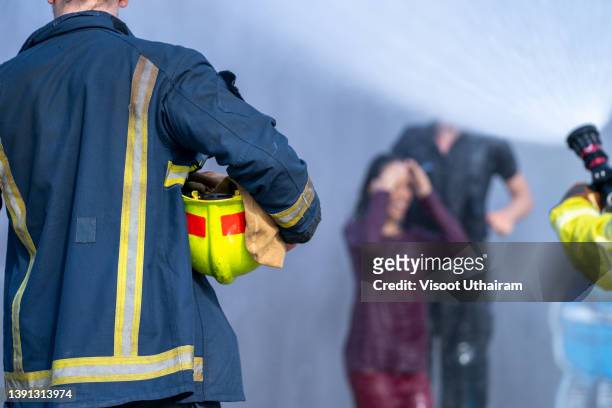 firefighter spraying high pressure water to fire,fireman using extinguisher and water for fight fire during fire fight training under danger situation. - pianificazione di emergenza foto e immagini stock