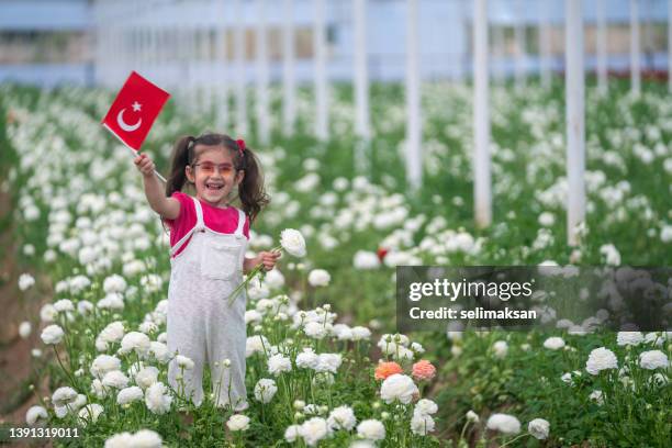 preschooler girl holding turkish flag in flower garden - april 5 stock pictures, royalty-free photos & images