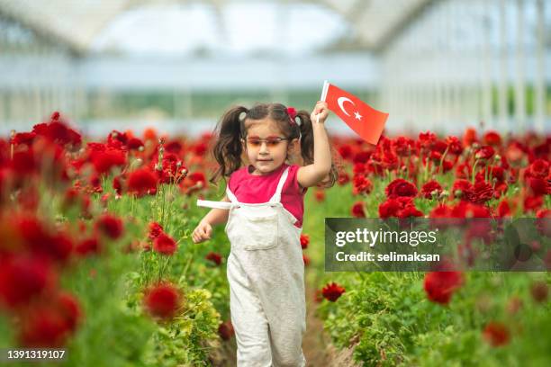 preschooler girl holding turkish flag in flower garden - april 5 stock pictures, royalty-free photos & images