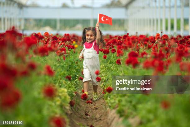 preschooler girl holding turkish flag in flower garden - april 5 stock pictures, royalty-free photos & images