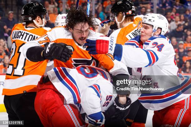 Zack MacEwen of the Philadelphia Flyers fights with Ryan Lindgren and Kaapo Kakko of the New York Rangers during the second period at Wells Fargo...