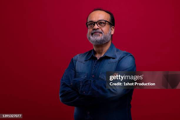 retrato de un joven de oriente medio con barba sobre fondo rojo. - east india company fotografías e imágenes de stock