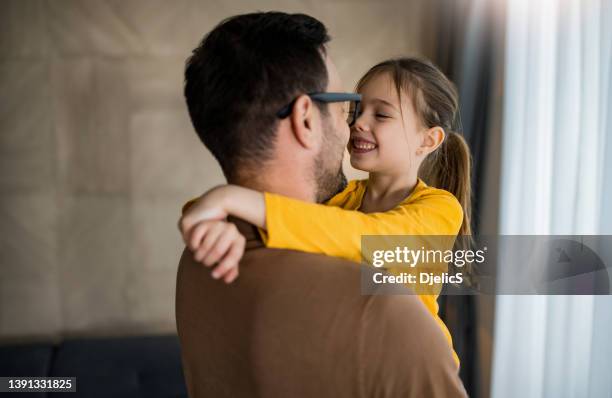 happy little girl embracing her father at home. - father in law stockfoto's en -beelden