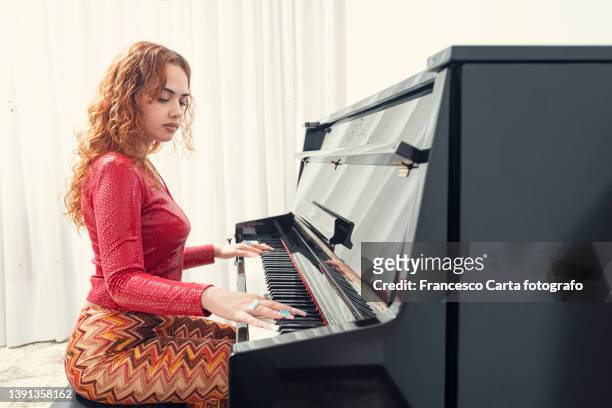 young woman  playing piano - pianist stock-fotos und bilder