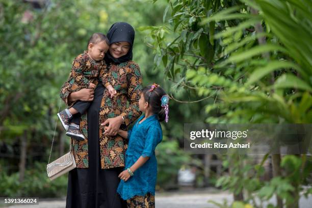 beautiful mother and daughter with batik dress - batik dress stock pictures, royalty-free photos & images