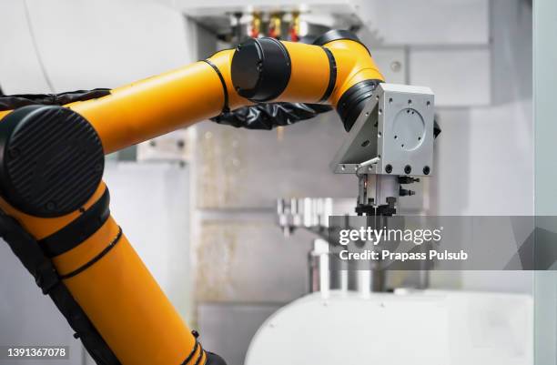 robot arm is picking machinery parts to cnc machine - cnc stock pictures, royalty-free photos & images