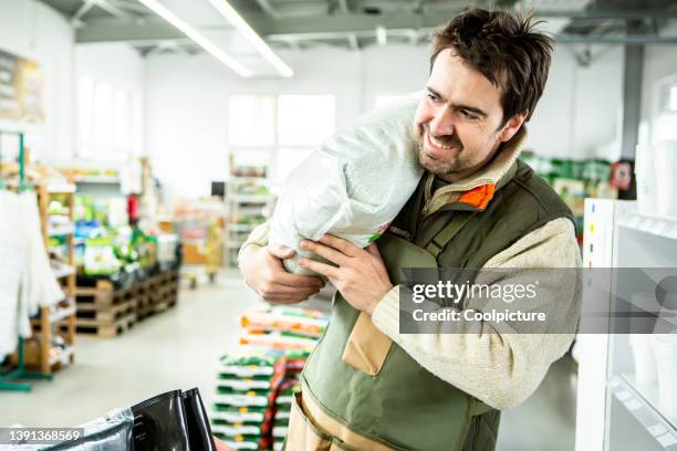 gardener in garden center - farmer fertilizer stock pictures, royalty-free photos & images