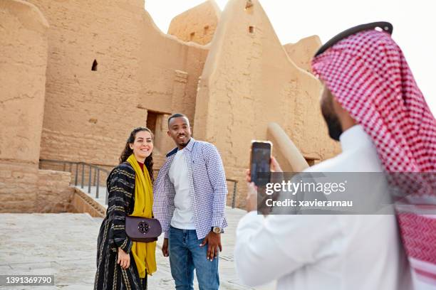 local guide photographing tourists with smart phone - riyadh stock pictures, royalty-free photos & images