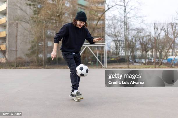 young man juggles football at urban soccer court - soccer man foto e immagini stock