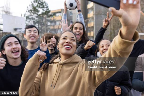 group of football players having fun taking a selfie on playing ground - street football stock-fotos und bilder