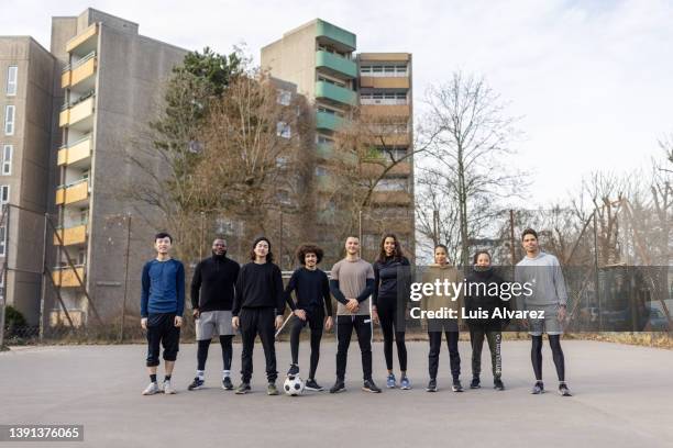 portrait of soccer team standing on urban football court - um do lado do outro - fotografias e filmes do acervo