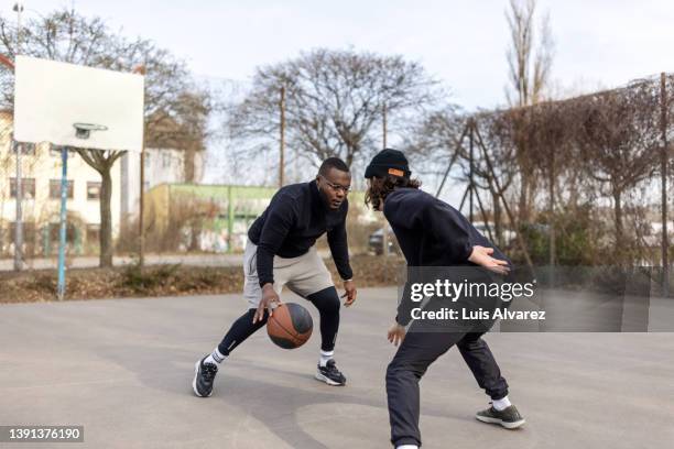 multi-ethnic players enjoying playing streetball on court - jogador de defesa imagens e fotografias de stock