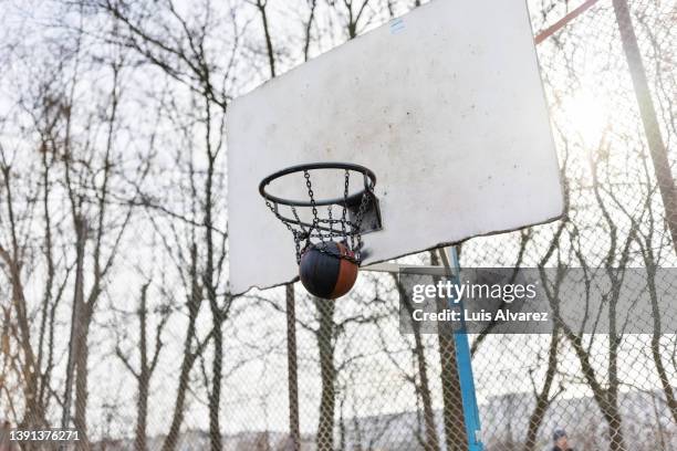 street basketball ball going through hoop - streetball stock pictures, royalty-free photos & images