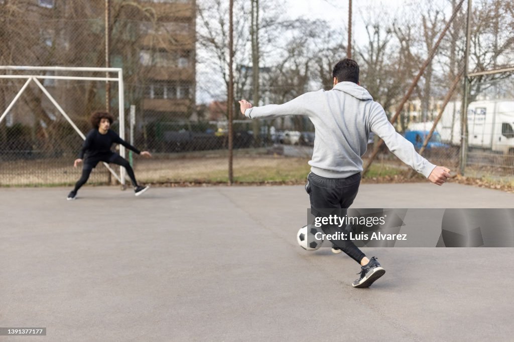 Young men playing soccer in the city