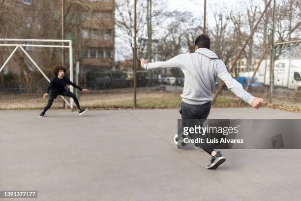 young men playing soccer in the city - trefferversuch stock-fotos und bilder