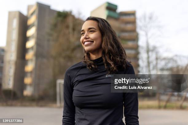 young hispanic woman standing at urban soccer court - roupa desportiva imagens e fotografias de stock