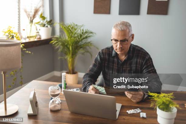 man talking to his doctor on a video call - mature man using phone tablet stock pictures, royalty-free photos & images