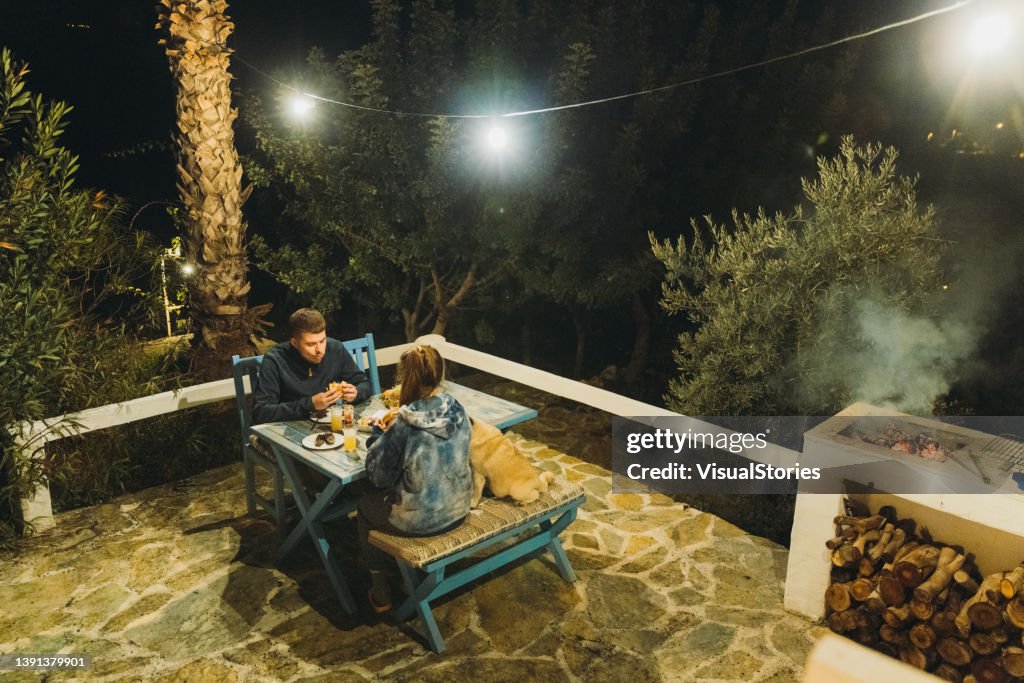 Weiblich und männlich beim Grillpicknick mit Burgern auf der heimischen Terrasse