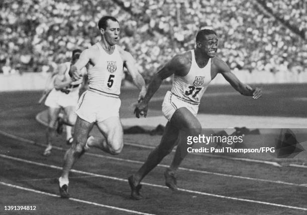 American athlete Wilbur Greer hands the baton to his teammate, American athlete Mozelle Ellerbe, in the first change of the 4x100 metres relay at the...
