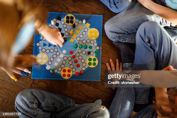 above view of unrecognizable kids playing ludo game on floor. - bordspel stockfoto's en -beelden