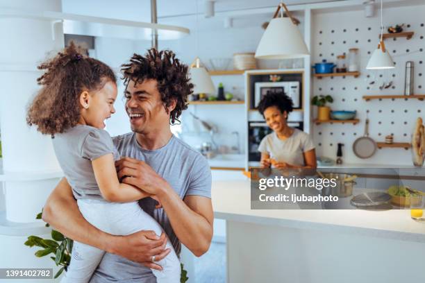 father embracing daughter at home - family law stockfoto's en -beelden