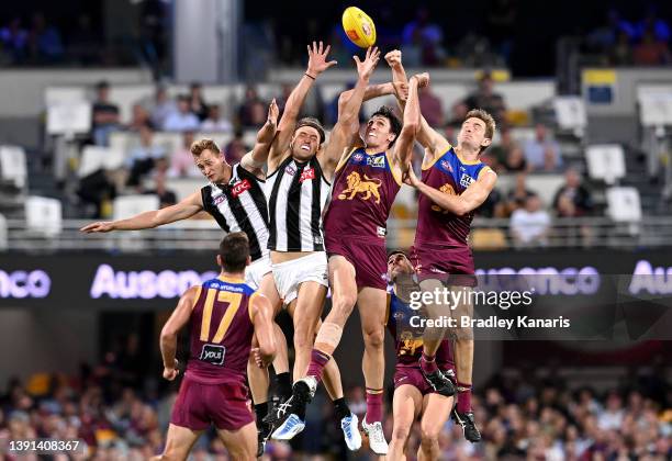 Oscar McInerney and Harris Andrews of the Lions challenge for the ball against Darcy Moore of the Magpies during the round five AFL match between the...