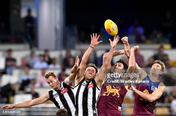 Oscar McInerney and Harris Andrews of the Lions challenge for the ball against Darcy Moore of the Magpies during the round five AFL match between the...