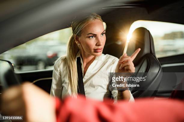 woman pointing whit a finger at the driver in the car - two finger stockfoto's en -beelden