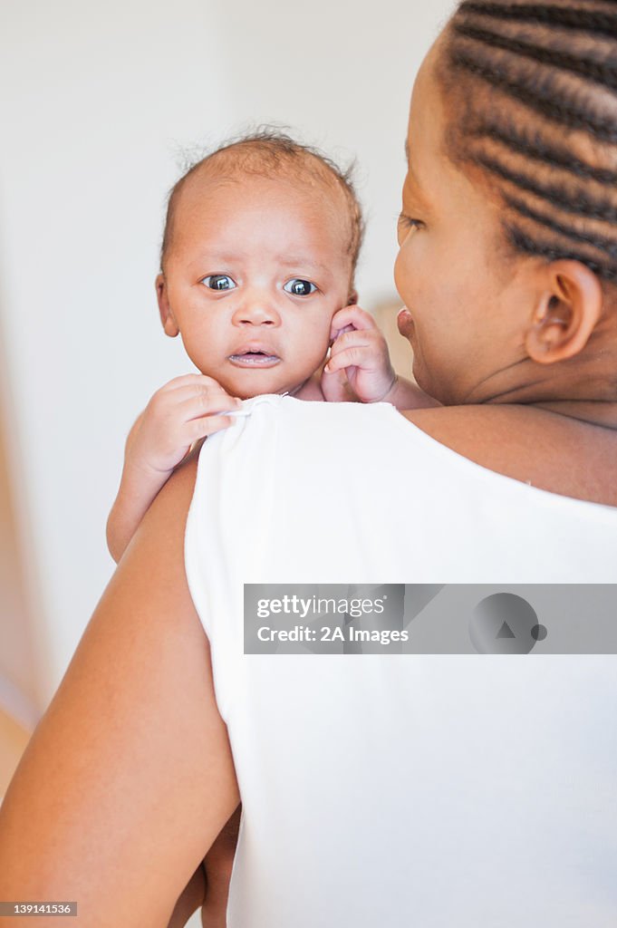 Portrait of newborn baby as it looks over its mothers shoulder in Johannesburg, South Africa