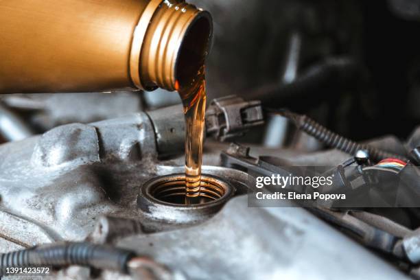 pouring motor oil to car engine - oil change fotografías e imágenes de stock