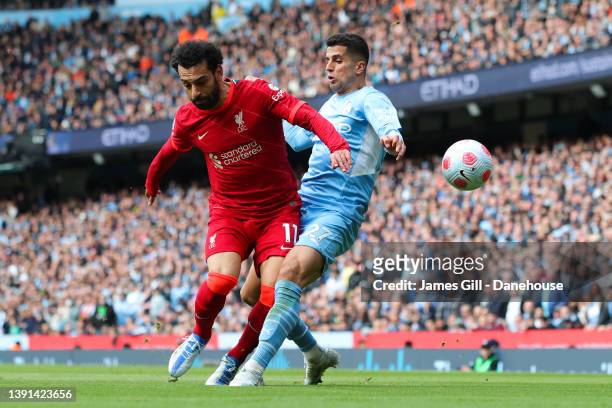 Mohamed Salah of Liverpool tackles Joao Cancelo of Manchester City during the Premier League match between Manchester City and Liverpool at Etihad...
