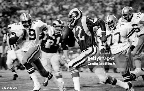 Los Angeles Rams QB James Harris scrambles while being pursued by Dallas Cowboys Harvey Martin and Bill Gregory during game action of the Los Angeles...