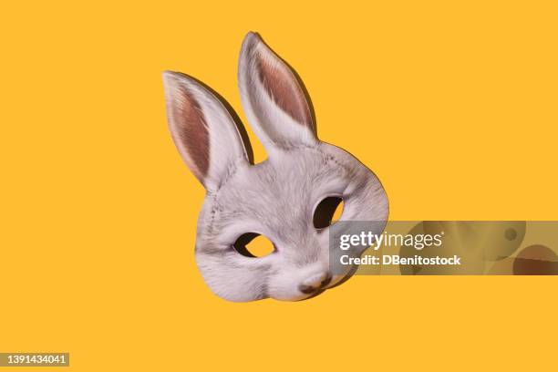 hare rabbit mask with hard shadow on yellow background. disguise, masquerade, carnival, easter and fun concept. - easter mask stock pictures, royalty-free photos & images