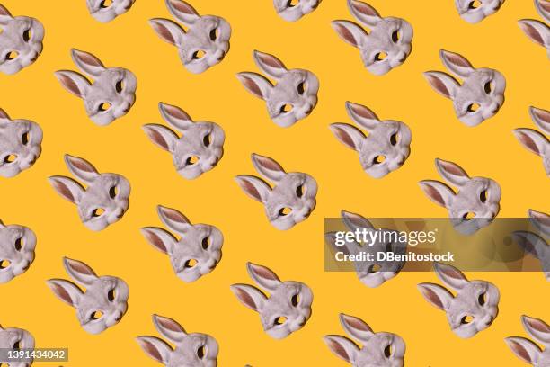 hare rabbit masks pattern with hard shadow on yellow background. disguise, masquerade, carnival, easter and fun concept. - easter bunny mask stockfoto's en -beelden