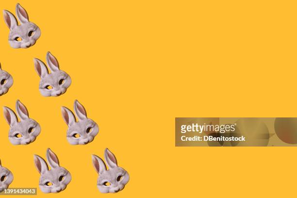 hare rabbit masks pattern with hard shadow. on the left side, on yellow background. disguise, masquerade, carnival, easter and fun concept. - easter bunny mask fotografías e imágenes de stock