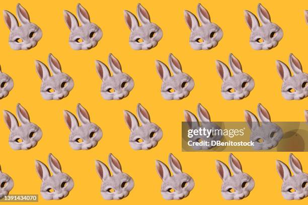 hare rabbit masks pattern with hard shadow on yellow background. disguise, masquerade, carnival, easter and fun concept. - easter bunny mask stockfoto's en -beelden