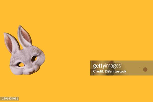 hare rabbit mask with hard shadow, on the left side, on yellow background. disguise, masquerade, carnival, easter and fun concept. - easter bunny mask fotografías e imágenes de stock