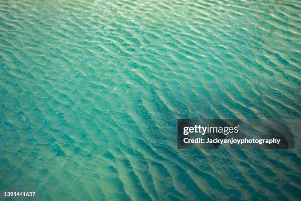 swimming pool surface with light reflection and water ripple patterns - water ripple stock-fotos und bilder