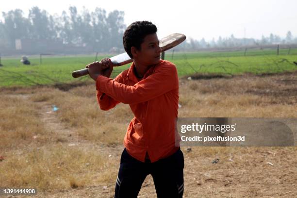 rural boy playing cricket in village - child batting stock pictures, royalty-free photos & images