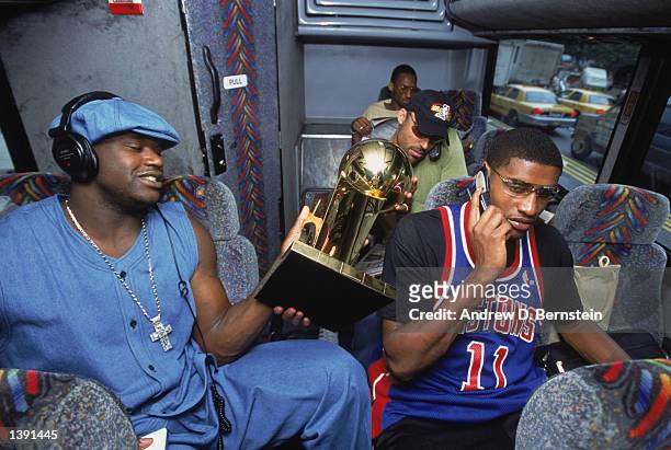 Center Shaquille O'Neal of the Los Angeles Lakers holds the championship trophy at the back of the team bus the day after winning Game Four of the...