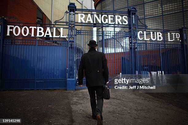 Man dressed in a bowler hat carrying a briefcase walks towards the Ibrox Stadium gates on February 17, 2012 in Glasgow, Scotland. Rangers face...
