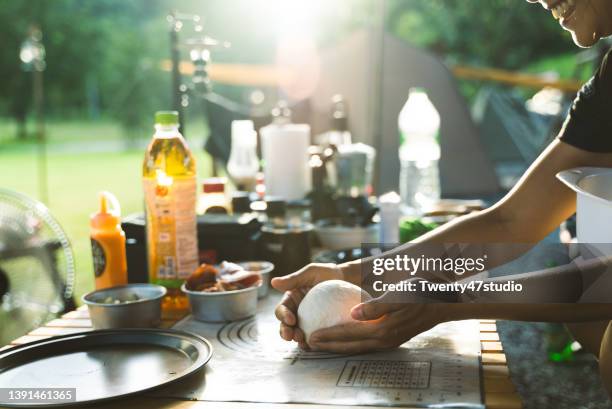 closeup woman hand kneading dough prepare for pizza - outdoor kitchen stock pictures, royalty-free photos & images