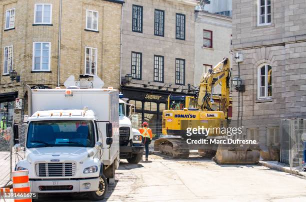 excavator and truck on street work - construction vehicle stock pictures, royalty-free photos & images