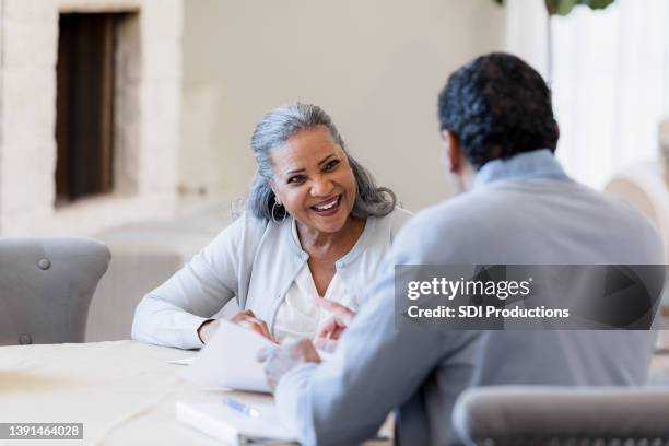 senior woman meets with financial advisor - two bank managers talking stock pictures, royalty-free photos & images