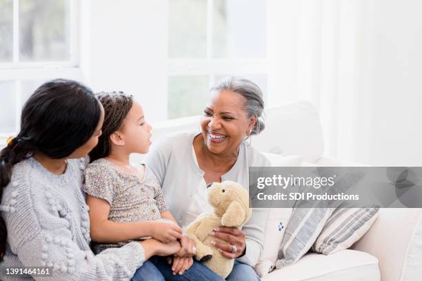 grandmother joyfully listens to her granddaughter - older widow stock pictures, royalty-free photos & images